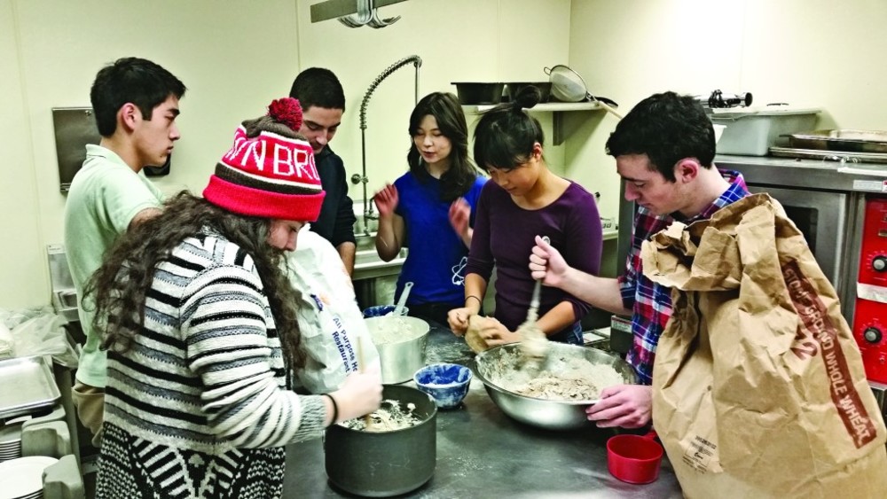 Students mix challah dough and chat with friends at Brown RISD’s  Challah for Hunger chapter. /ARIEL BROTHMAN